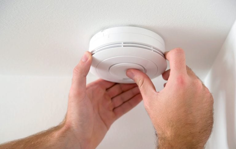 Man,Installing,Smoke,Or,Carbon,Monoxide,Detector