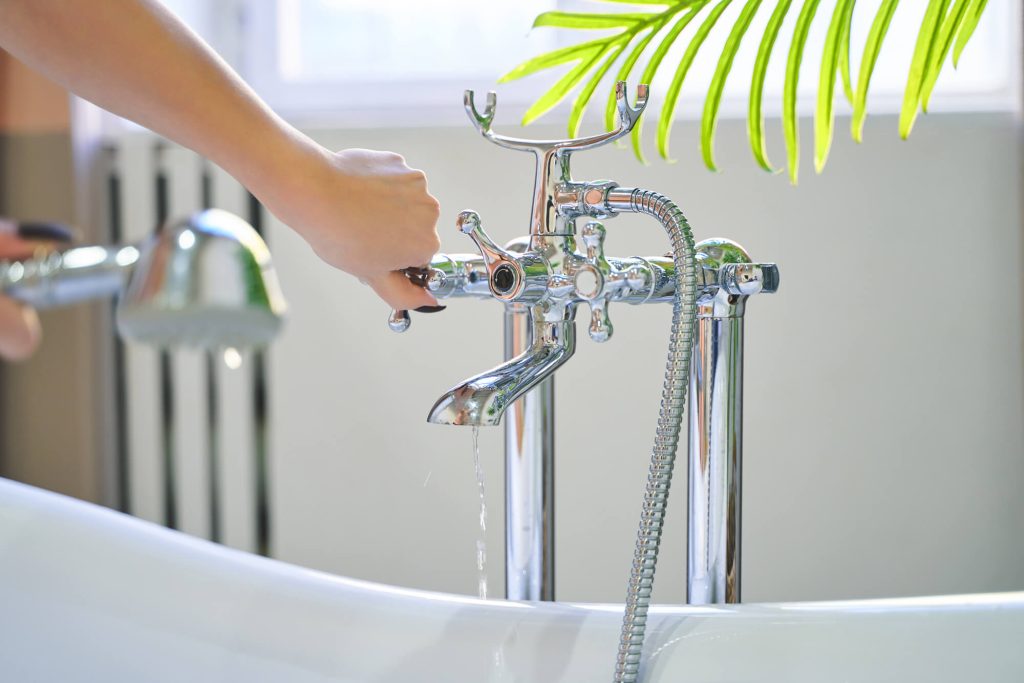 woman conserving water by turning off bath tap