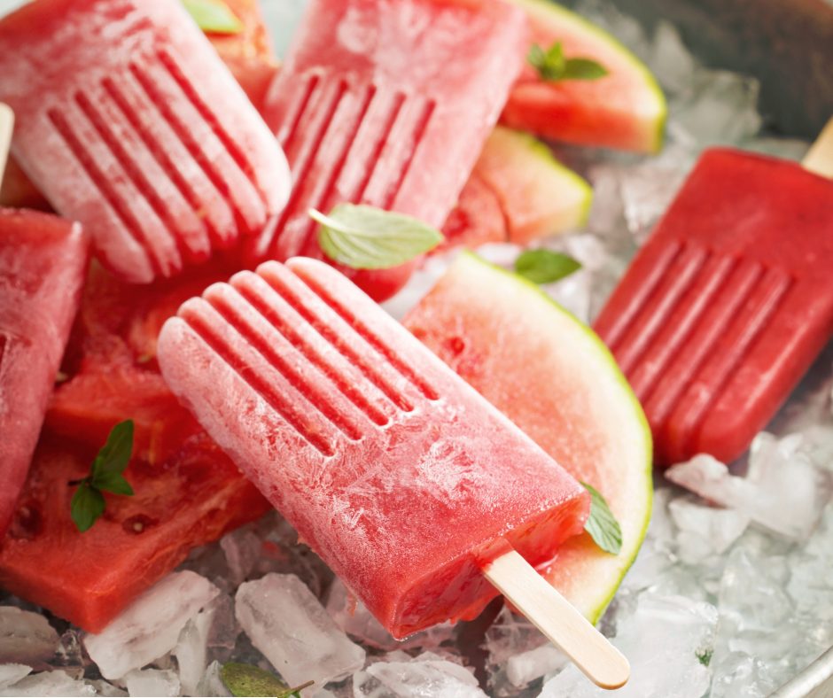 Watermelon ice blocks with fresh watermelon slices and mint leaves on ice.