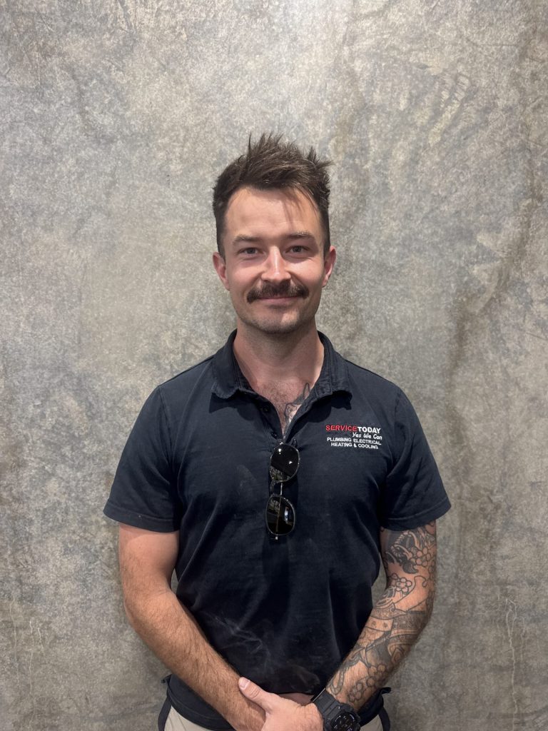 Jesse Gray wearing a black Service Today uniform, celebrating 10 years with the company.
