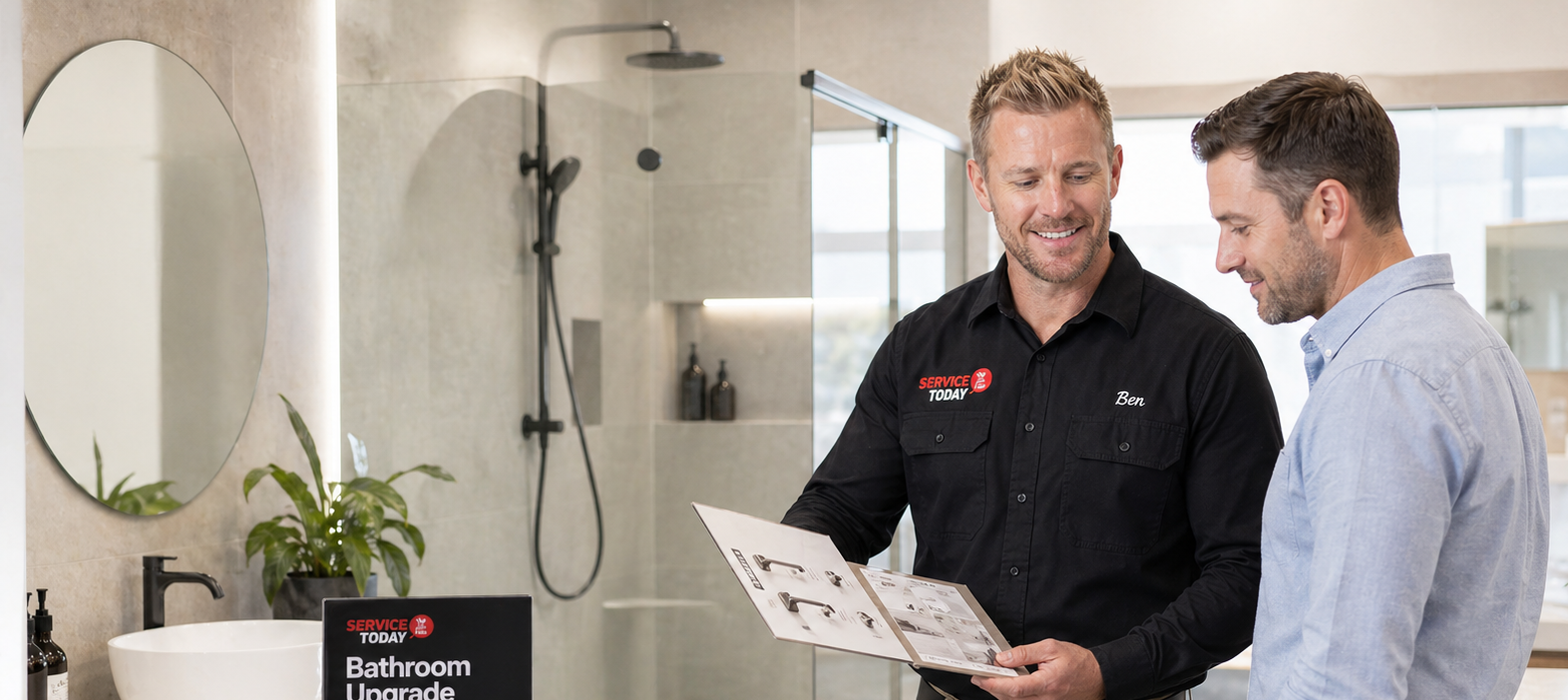 A bathroom upgrade consultant shows a client a brochure of bathroom fixtures.