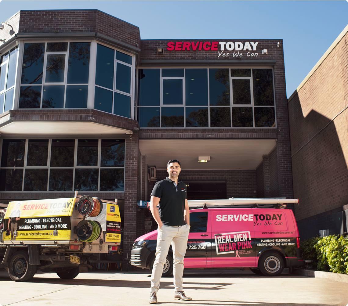 Service Today owner stands with company vans outside their building.