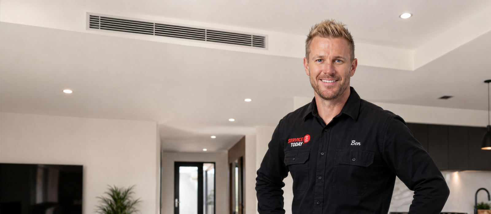 Man named Ben in a Service Today uniform smiling, with ducted air conditioning vent visible above.