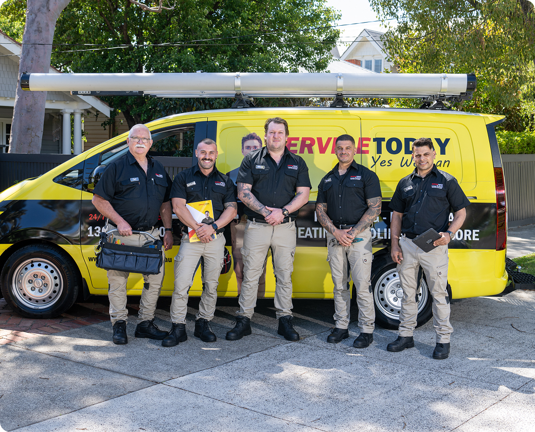 Service Today team in uniform standing by their branded yellow van.